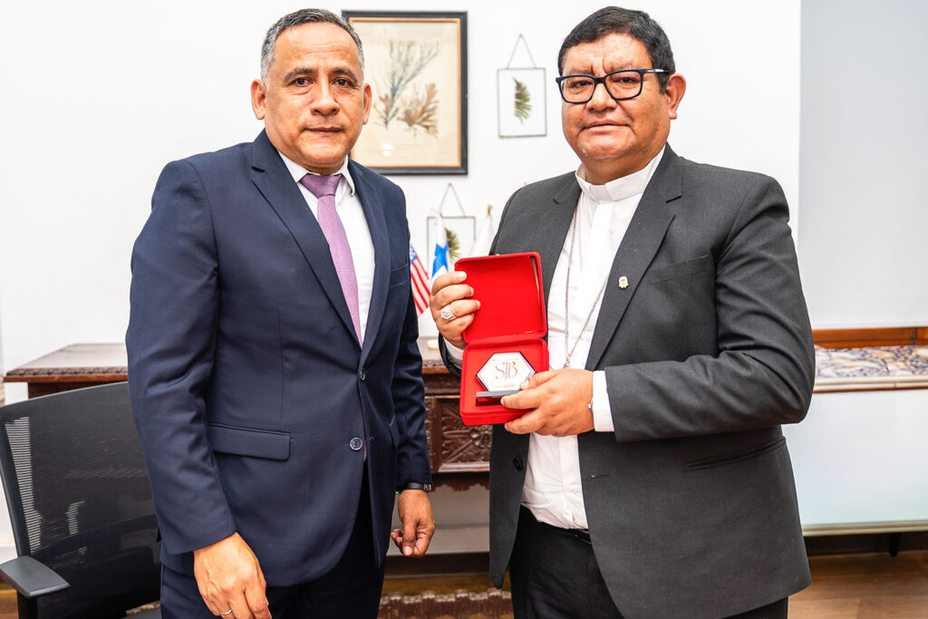 En señal de agradecimiento y colaboración, el Dr. Alfredo Mendieta Leyva, rector de la UPSJB, hace entrega de una placa institucional al Reverendo Monseñor Miguel Ángel Contreras Llajaruna.
