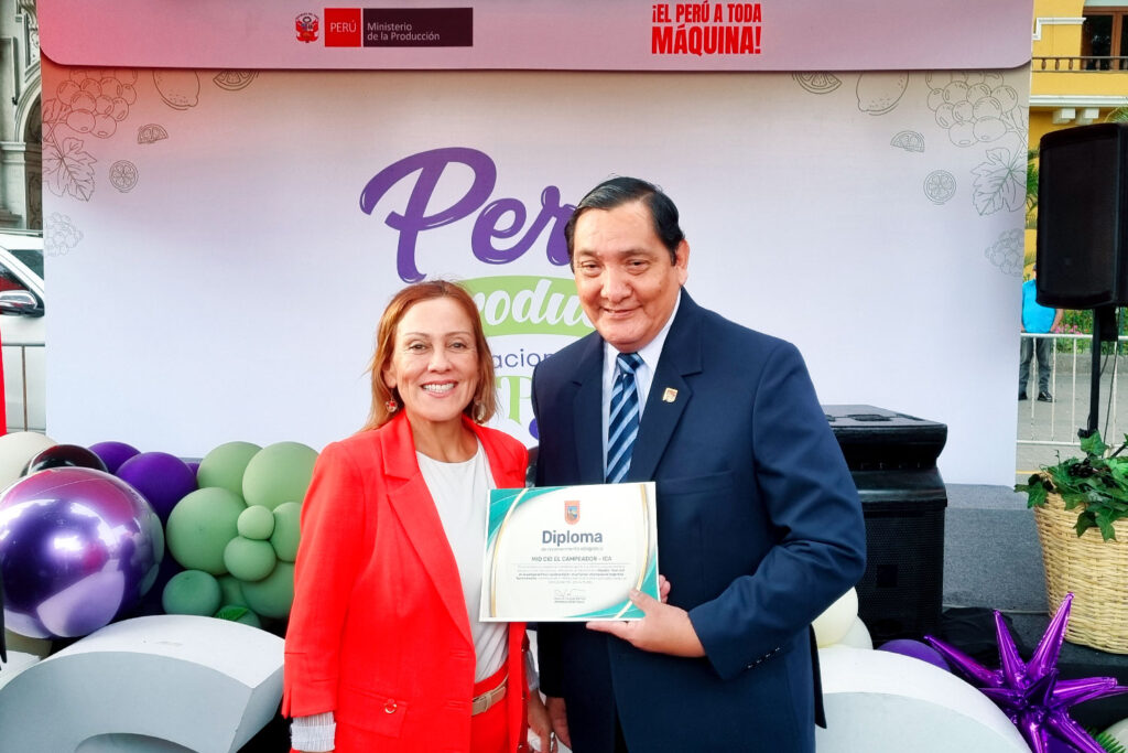 El Lic. Raúl Castilla, miembro del equipo de eventos de la Universidad Privada San Juan Bautista, recibe el diploma de reconocimiento otorgado al Pisco Mío Cid El Campeador.