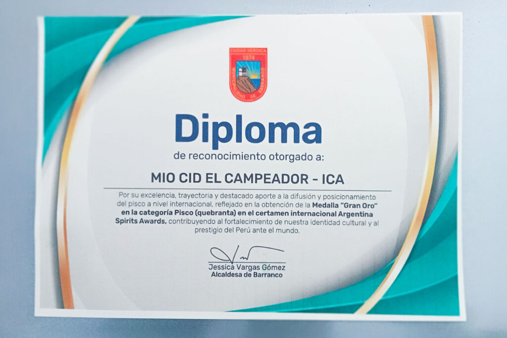 Fotografía del diploma de reconocimiento otorgado al Pisco Mío Cid El Campeador, proyecto de la UPSJB, tras su premio Gran Oro internacional.