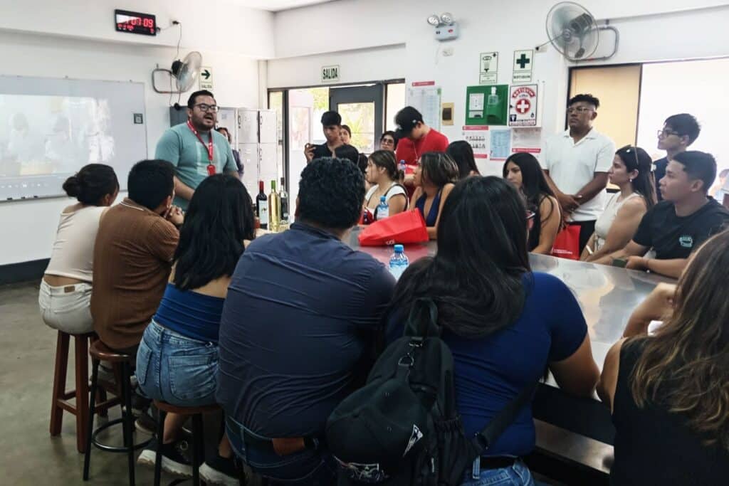 Personal de la UPSJB conversa con padres e ingresantes alrededor de una mesa durante jornada informativa.
