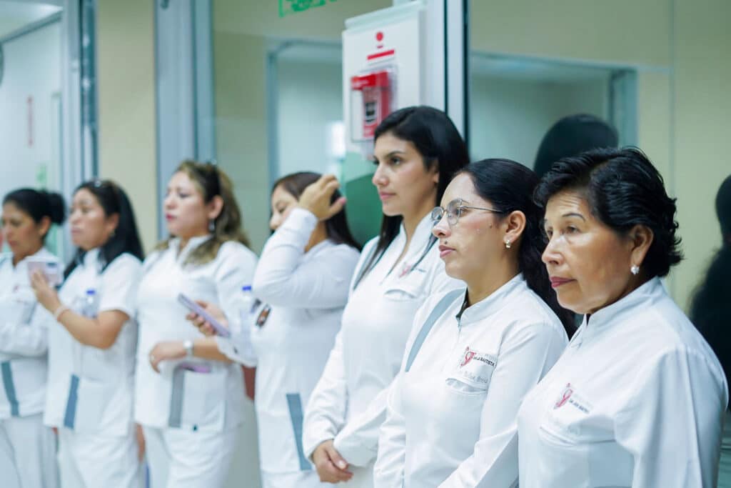 residentes-endodoncia-upsjb-pasantia-internacional Residentes de Endodoncia de la UPSJB con chaquetas blancas institucionales alineadas y prestando atención durante una actividad de la pasantía.