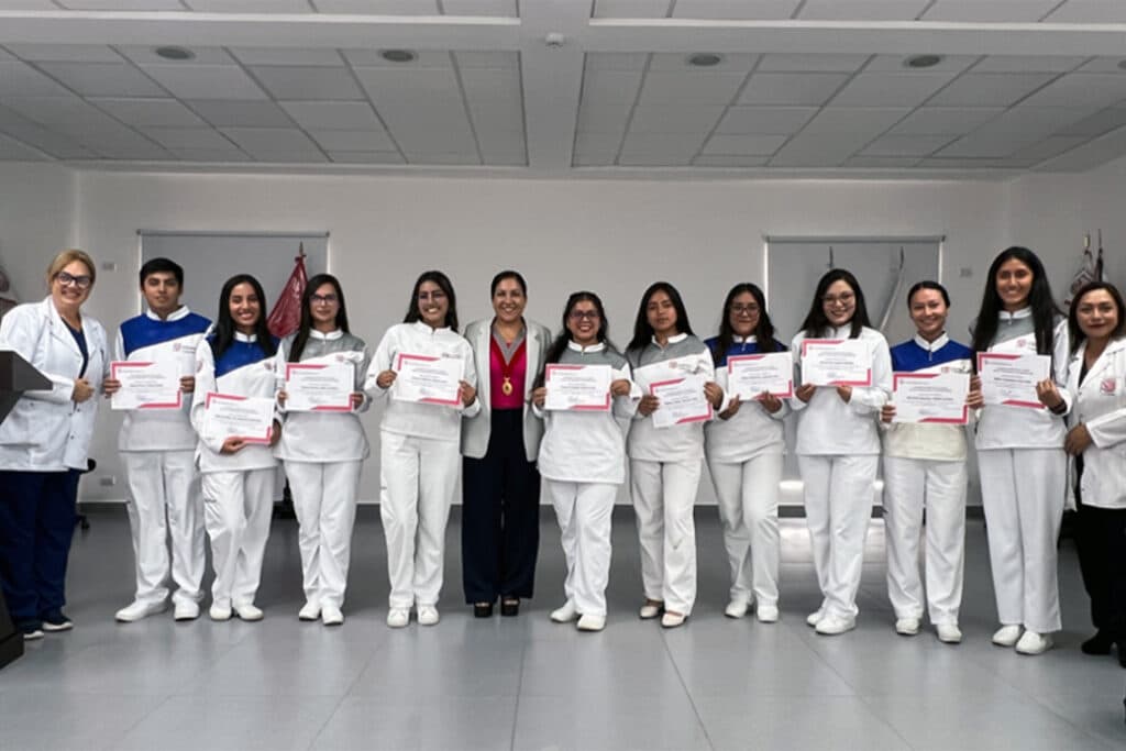 Estudiantes de Estomatología de la UPSJB posan con constancias junto a la Mag. Goretty García Luna durante la ceremonia La Primera Sonrisa UPSJB.
