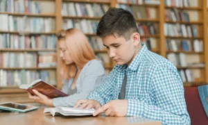 Alumnos universitarios estudiando en una biblioteca de una universidad que brinda educación de calidad.