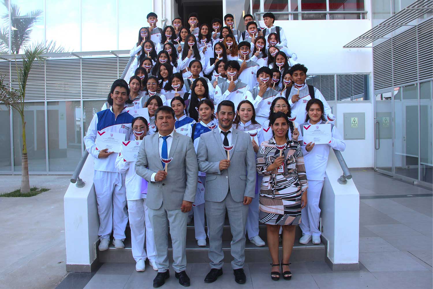 Estudiantes de primer ciclo de Estomatología de la UPSJB Ica junto a autoridades, durante la ceremonia La Primera Sonrisa, posando con sonrisas simbólicas.