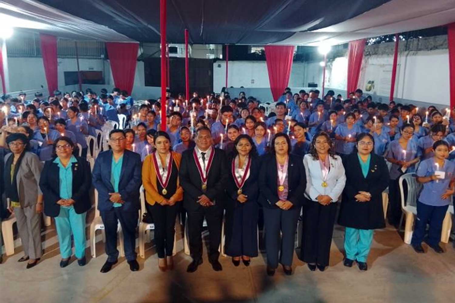 Estudiantes de Enfermería sostienen velas junto a autoridades durante la Ceremonia de la Luz en la UPSJB Filial Chincha.