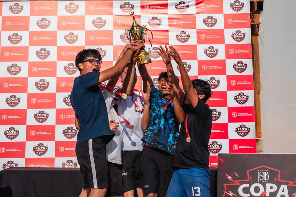 Copa Cachimbo 2026: la UPSJB fortaleció la integración estudiantil en Lima, Ica y Chincha 8 Grupo de estudiantes levantando el trofeo de campeón durante la premiación de la Copa Cachimbo 2026 en el campus Chorrillos de la UPSJB.