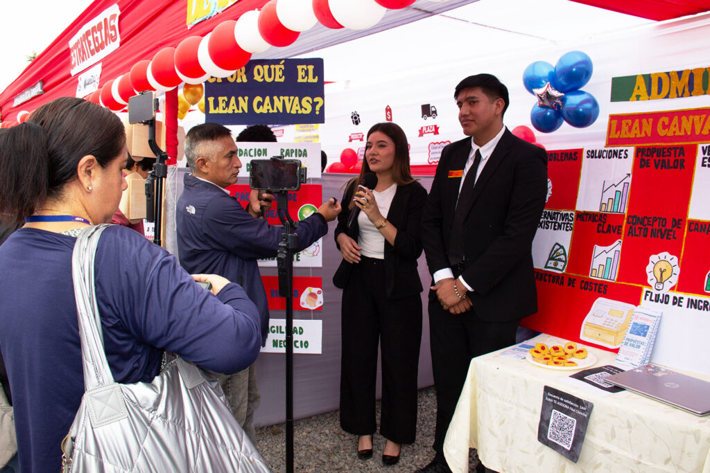 Estudiantes de Administración explican herramientas de gestión empresarial durante una entrevista realizada por un medio de comunicación local en la actividad "San Juan Te Asesora".