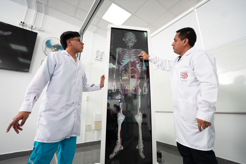 Docente y estudiante de Medicina Humana de la UPSJB utilizando tecnología de anatomía digital como parte de su formación académica acreditada internacionalmente.