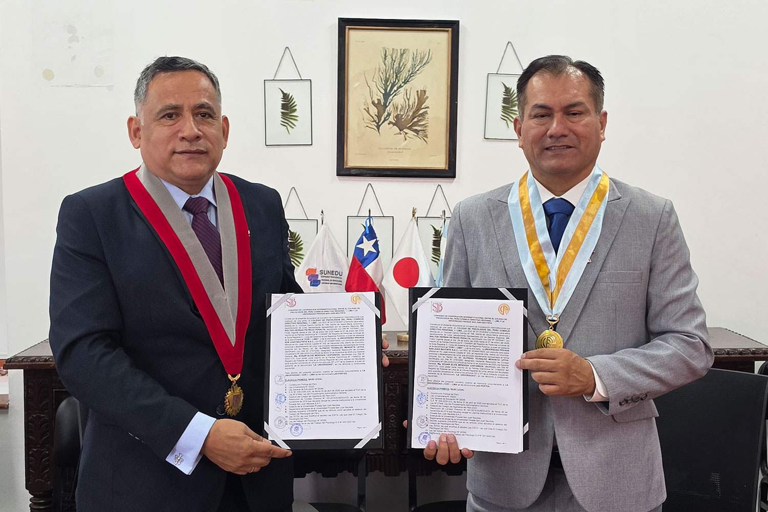 El Dr. Alfredo Mendieta Leyva y el Dr. Walter Hernán Patricio Peralta muestran los ejemplares del convenio de cooperación interinstitucional firmado entre la UPSJB y el Colegio de Psicólogos del Perú.