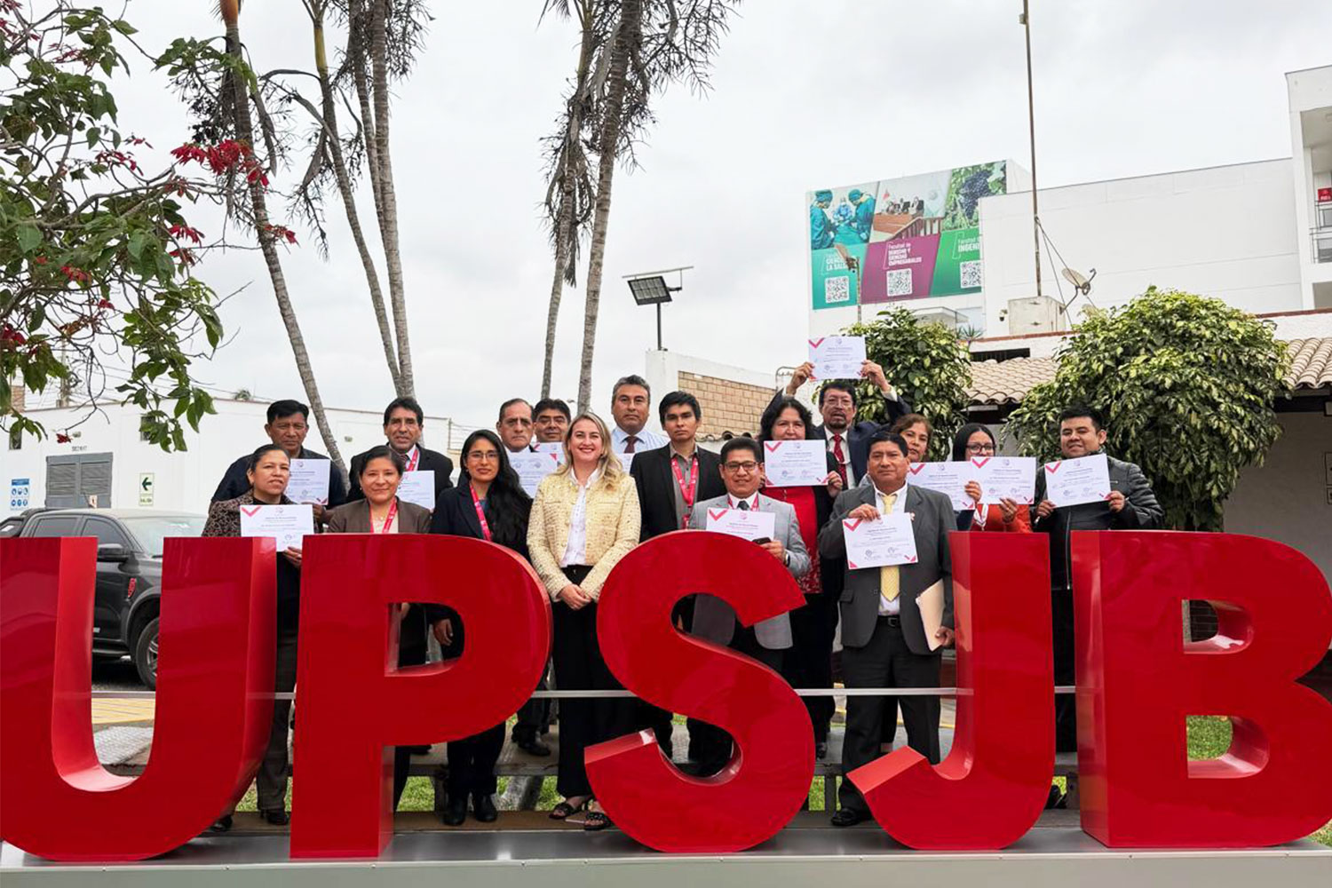 Docentes de la Facultad de Derecho y Ciencias Empresariales de la Universidad Privada San Juan Bautista posan con sus diplomas de reconocimiento a docentes universitarios junto a la decana durante la ceremonia por el Día del Docente Universitario.