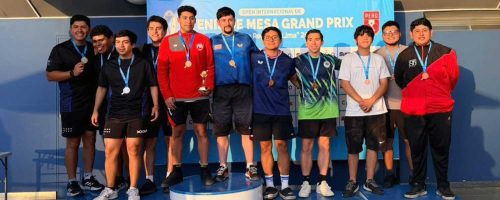 Un grupo de ocho estudiantes hombres de la UPSJB en un podio recibiendo medallas de bronce en el Open Internacional de Tenis de Mesa 2026.
