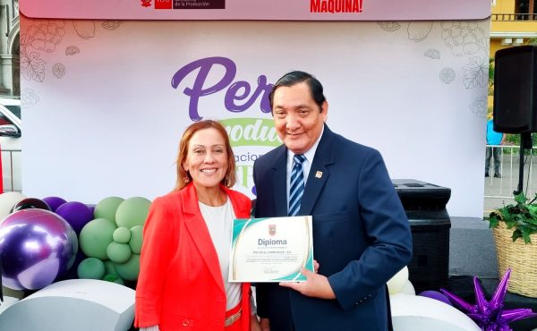 El Lic. Raúl Castilla, miembro del equipo de eventos de la Universidad Privada San Juan Bautista, recibe el diploma de reconocimiento otorgado al Pisco Mío Cid El Campeador.
