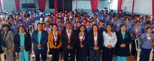 Estudiantes de Enfermería sostienen velas junto a autoridades durante la Ceremonia de la Luz en la UPSJB Filial Chincha.