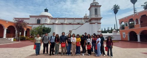 studiantes de la UPSJB posan frente a la capilla y la arquitectura colonial de la histórica sede de la universidad en Chorrillos.