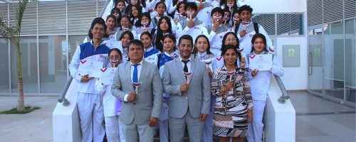Estudiantes de primer ciclo de Estomatología de la UPSJB Ica junto a autoridades, durante la ceremonia La Primera Sonrisa, posando con sonrisas simbólicas.